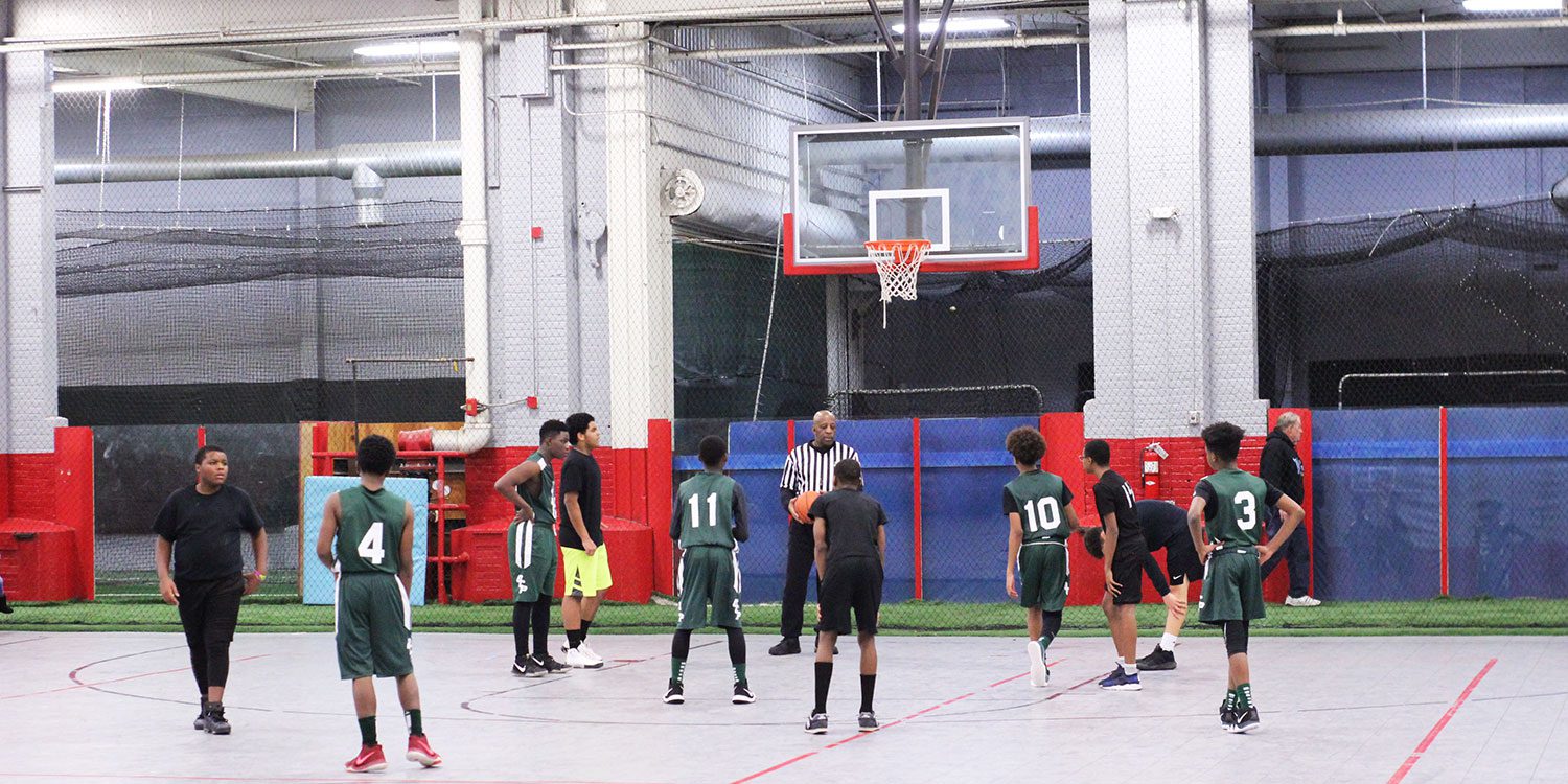 Students playing in a competitive basketball game.